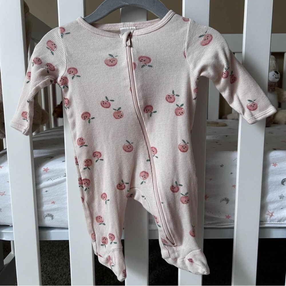 Pink baby onesie with peaches